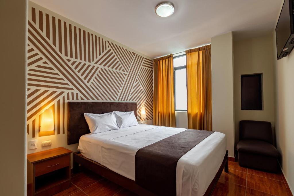 皮乌拉里奥布兰科酒店的配有一张床和一把椅子的酒店客房