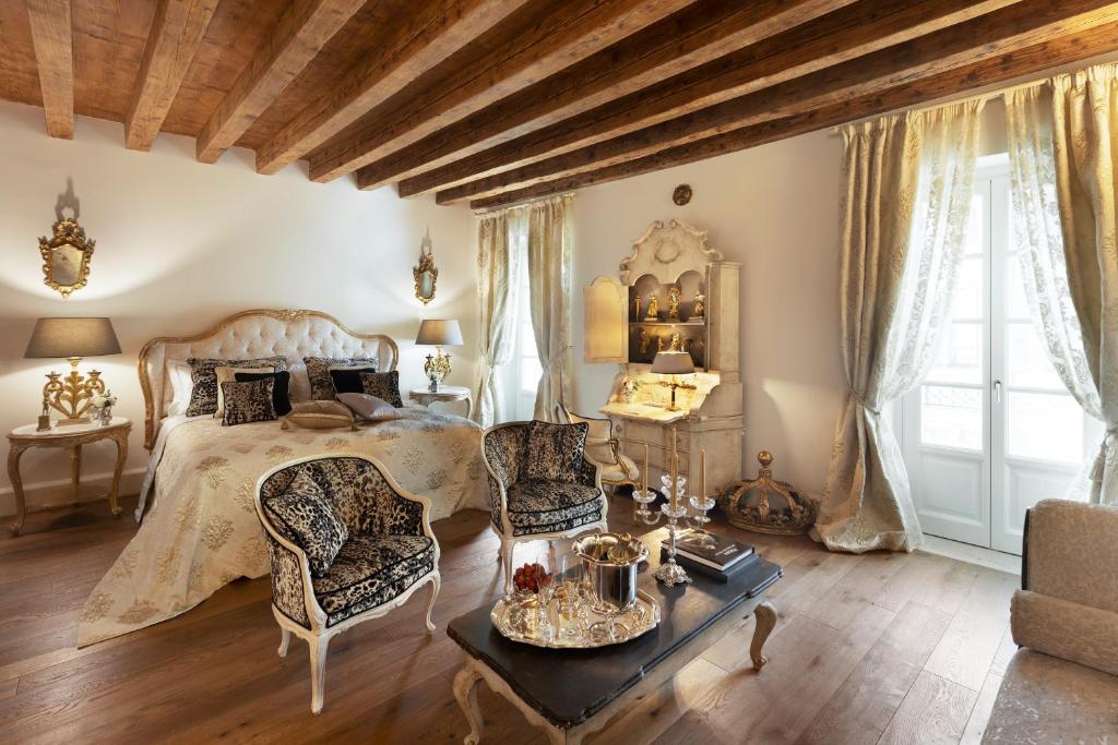 代森扎诺-德尔加达Antica Dimora Desenzano的卧室配有一张床和一张桌子及椅子