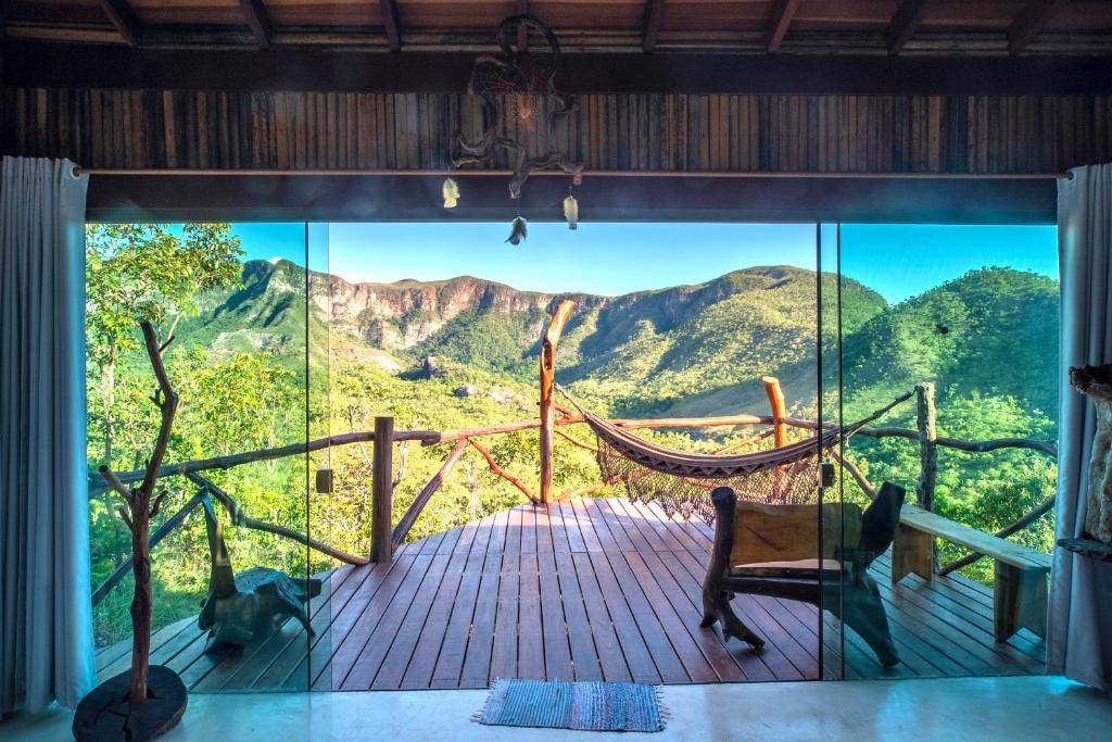 戈亚斯州上帕莱索Ecopousada Toca do Guará的客房设有吊床,享有山景