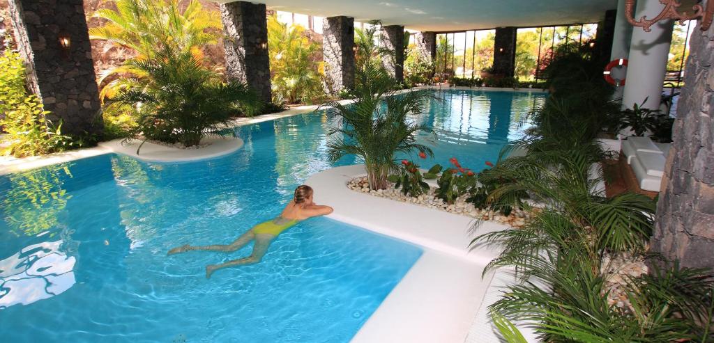 埃尔帕索La Palma Jardín Resort的女人在游泳池游泳