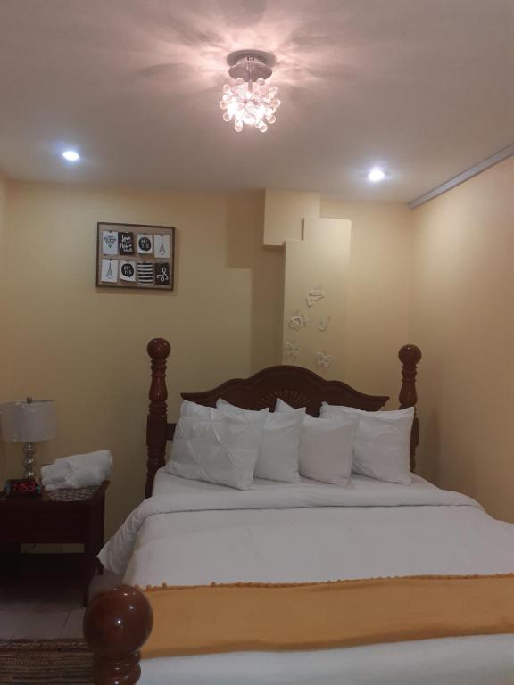 Bon AccordEssentials Suite的卧室配有带白色枕头的大床
