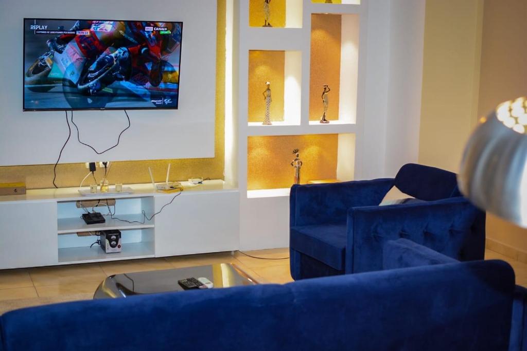 杜阿拉Appartement Cosy 3 bonapriso的客厅配有2把蓝色椅子和电视