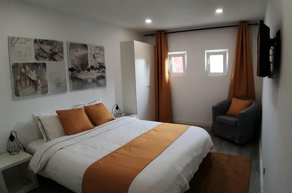 里斯本因卡纳克之家度假屋的一间卧室配有一张大床和一把椅子