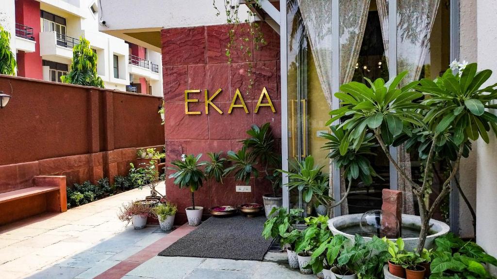 阿格拉Ekaa Villa near Taj Mahal的一座庭院,里面种有植物,建筑上有一个标志