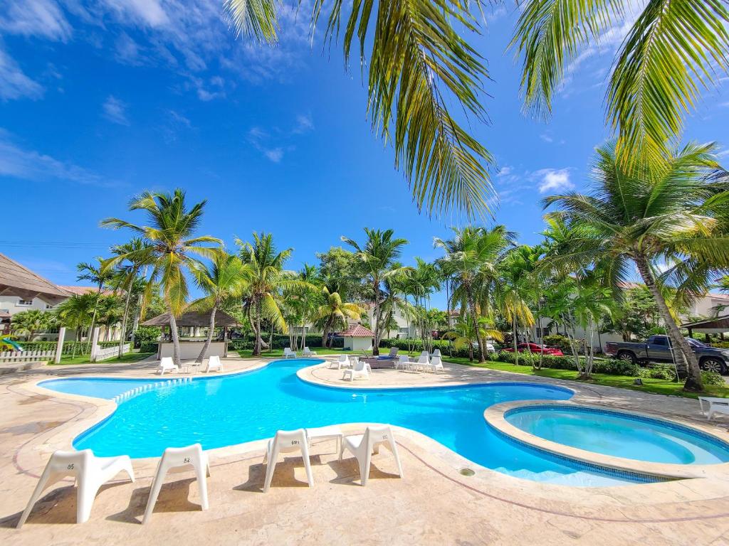 蓬塔卡纳Blue Heaven Guest House Bávaro, Punta Cana, Ideal For Couples的一个带椅子的游泳池,棕榈树