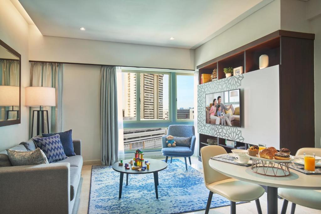 新加坡Somerset Bencoolen Singapore的客厅配有沙发和桌子