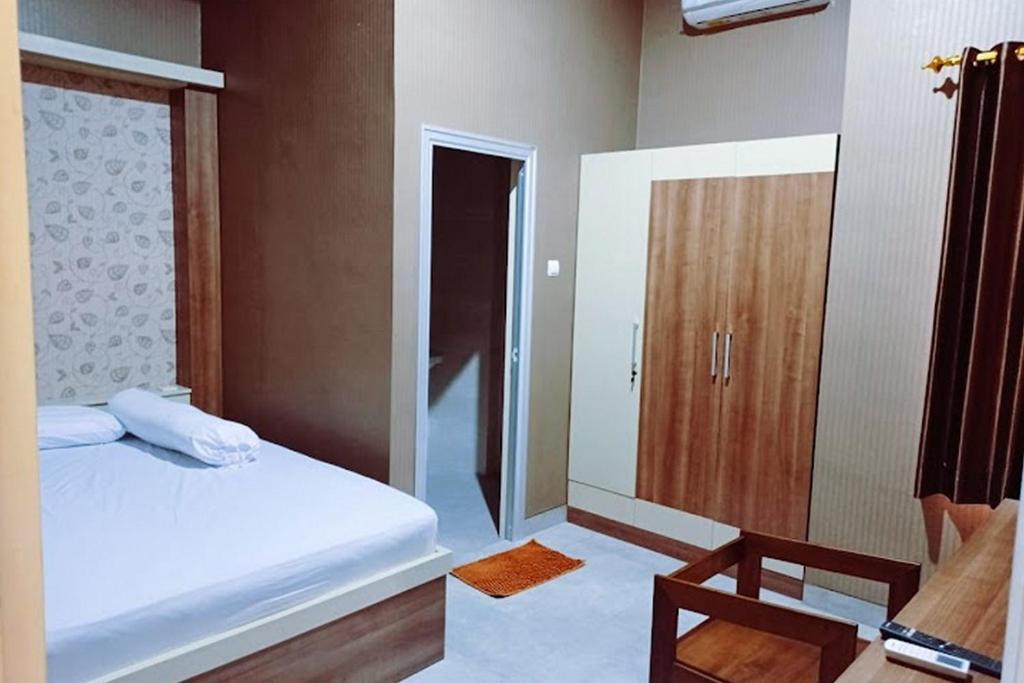 KudusRedDoorz near Simpang Tujuh Kudus的一间卧室配有一张床和一个木制橱柜