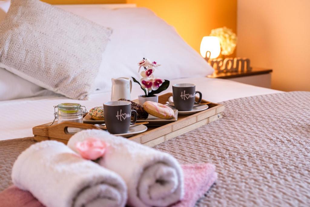 苏佩塔尔Villa Ankora的床上的托盘,上面有毛巾和咖啡杯