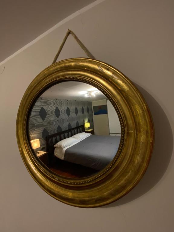 那不勒斯Magione Serra的墙上的镜子,房间里的床