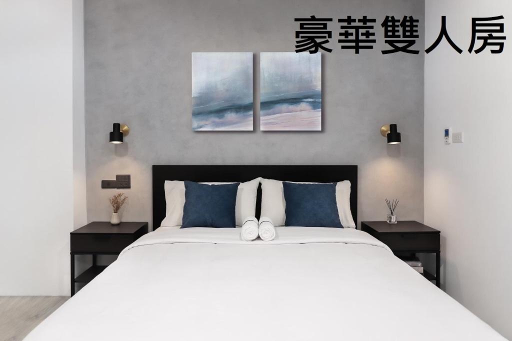 屏东县子琪大饭店的卧室配有一张带两张桌子的大型白色床