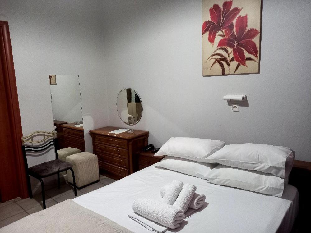 比雷埃夫斯科里达罗斯酒店的卧室配有白色的床和镜子