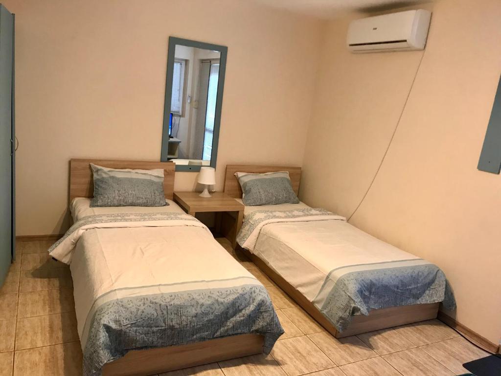 瓦尔纳Ssenyange Guest House的带两张床和镜子的客房