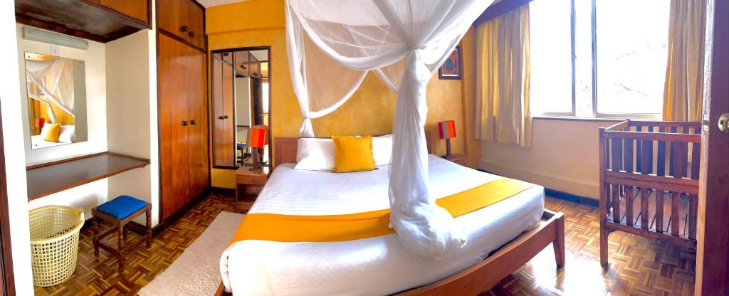 内罗毕Kenya Comfort Suites的一间卧室配有一张带天蓬的床