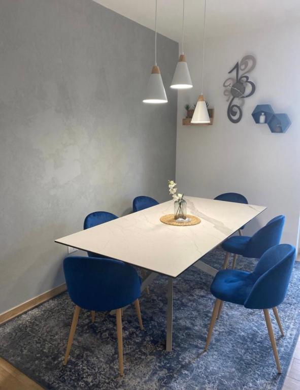 圭多尼亚Casa Molly appartamento Guidonia Tivoli terme的一间配备有白色桌子和蓝色椅子的用餐室
