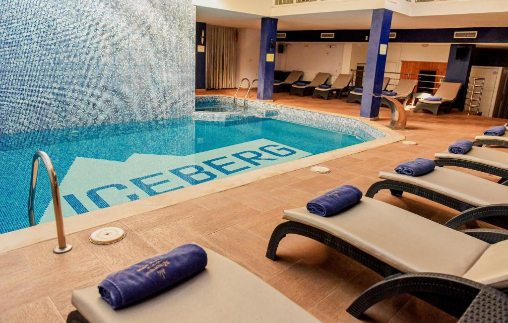 班斯科班斯科冰山酒店的酒店大堂的游泳池,配有椅子