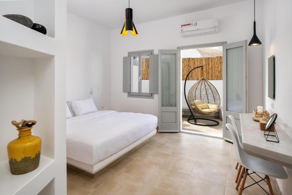 皮尔戈斯Astivi Santorini Apartments的一间卧室配有一张床、一张桌子和一张桌子