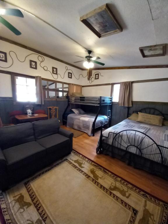 坎顿Acorn Hideaways Canton Old West Bunkhouse for 9 - Trail's End Corral的一间带两张床和一张沙发的客厅