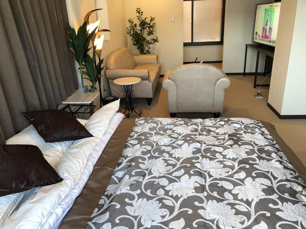 小樽Cool-inn Otaru的一间卧室配有一张床、一张沙发和一把椅子
