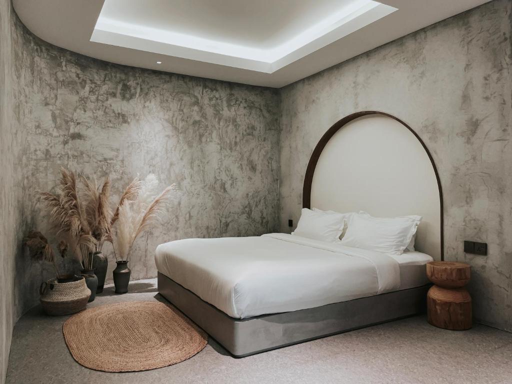 哥打京那巴鲁The Cara Boutique Hotel的卧室配有一张白色床和拱形床头板