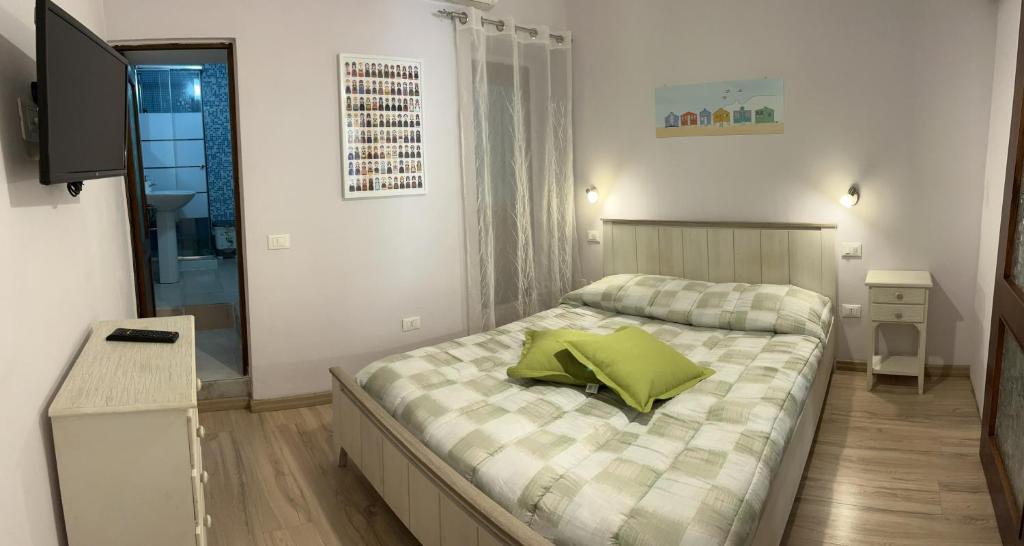 卡利亚里Casa Victoria的一间卧室配有一张带绿色枕头的床