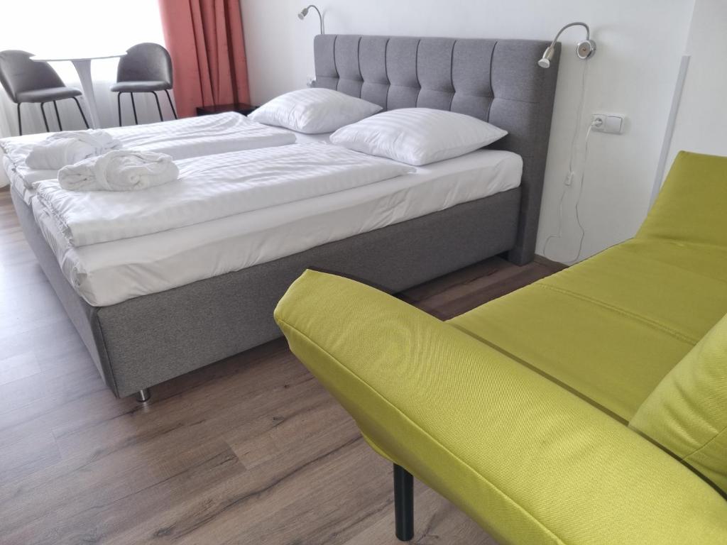 弗林布尔克Ubytování Hanka v hotelovém pokoji C408的一间卧室配有一张大床和一张黄色椅子