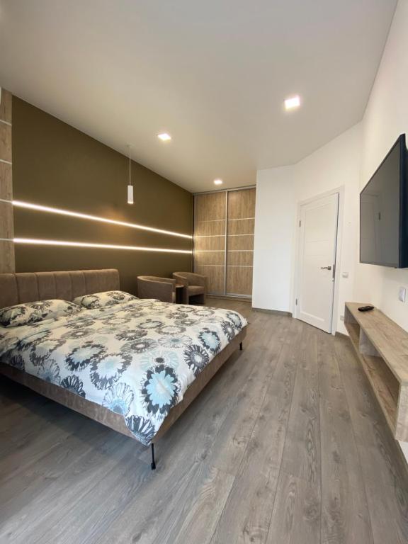 罗夫诺Чудова квартира в центрі міста的一间卧室配有一张床和一台平面电视
