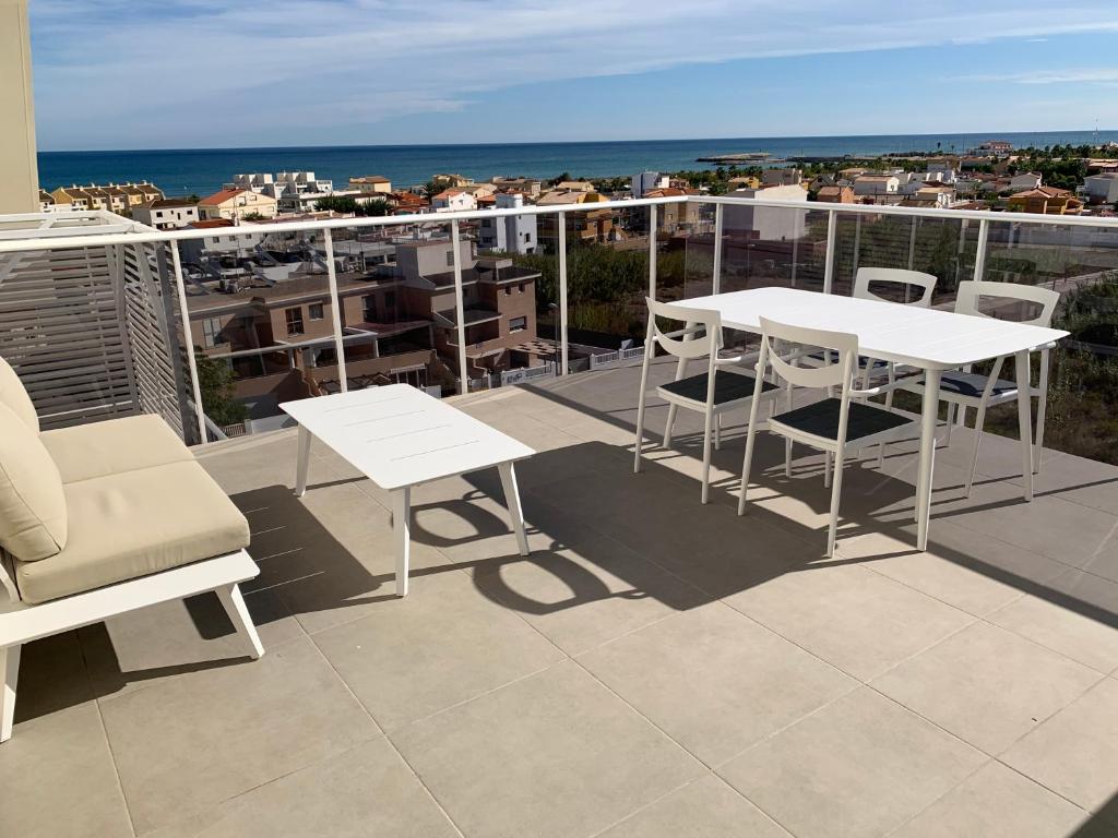 奥利瓦Penthouse panoramic sea view的阳台配有白色的桌椅,享有海景。