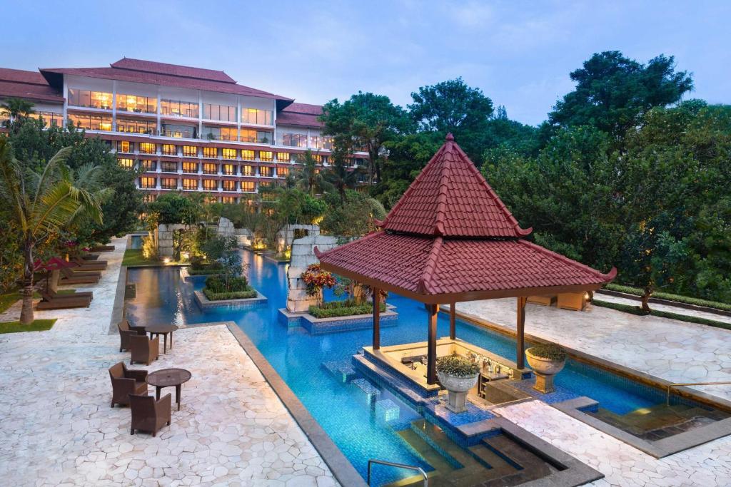 日惹Sheraton Mustika Yogyakarta Resort and Spa的一个带游泳池的度假胜地和一家酒店