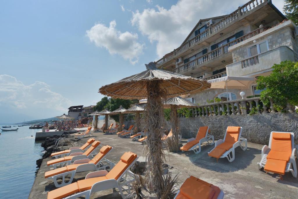 蒂瓦特Apartments Palace Mira Mare的海滩上的一组躺椅和遮阳伞