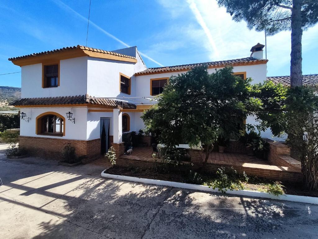 普里埃格·德·科尔多巴Paredejas del Rey的一座白色和橙色的房子,前面有树木