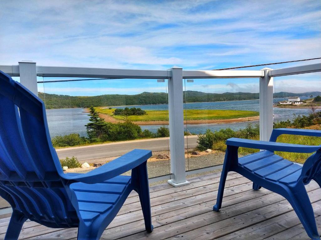 Arnold's CoveThe Killick Inn & Suites的甲板上配有两把蓝色椅子,享有水景