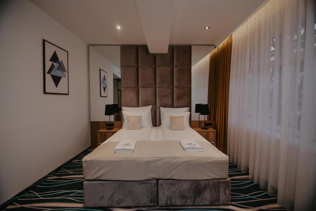 图兹拉Hotel Vertigos的一间卧室,卧室内配有一张大床
