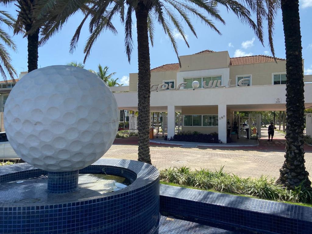 阿奎拉兹Conforto e Lazer no Golf Ville Resort Alto Padrão的棕榈树建筑前的高尔夫球