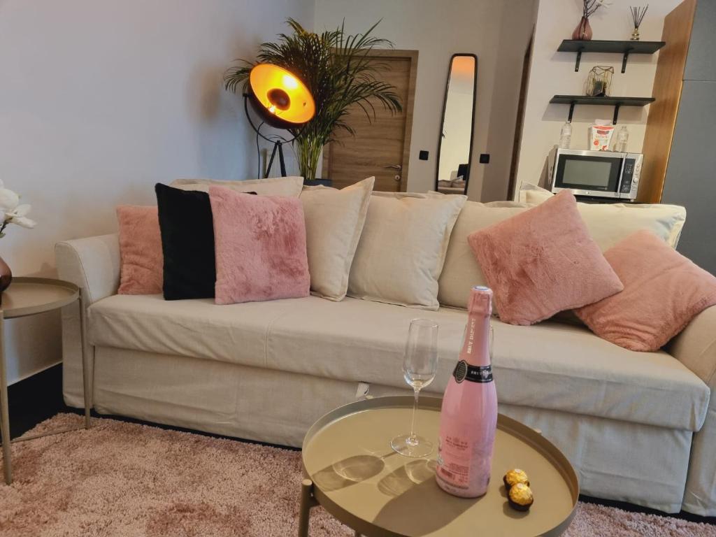 列日La suite de lati的客厅配有白色沙发及一瓶香槟