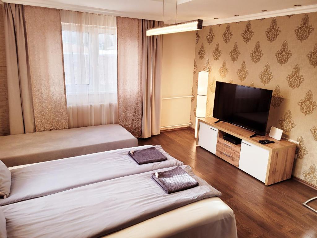 尼赖吉哈佐Indira Vendégház的酒店客房设有两张床和一台平面电视。