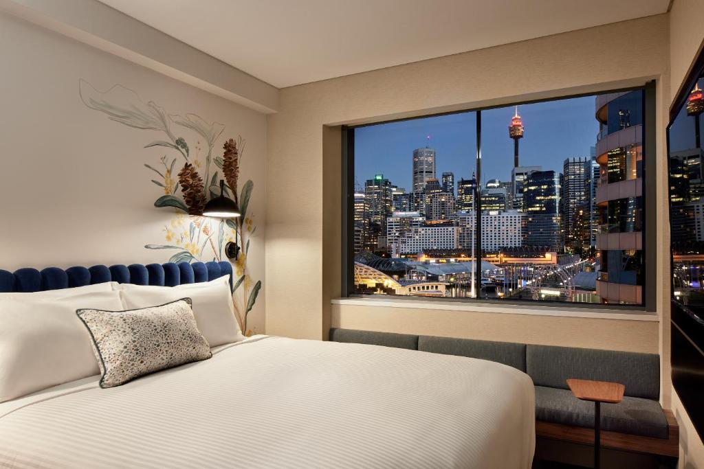悉尼Aiden by Best Western Darling Harbour的一间卧室设有大窗户,享有城市景观