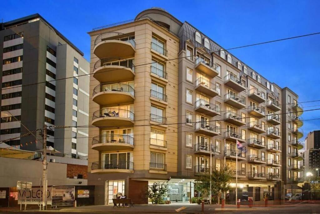 墨尔本Melbourne South Yarra Central Apartment Hotel Official的一座高大的建筑,旁边设有阳台