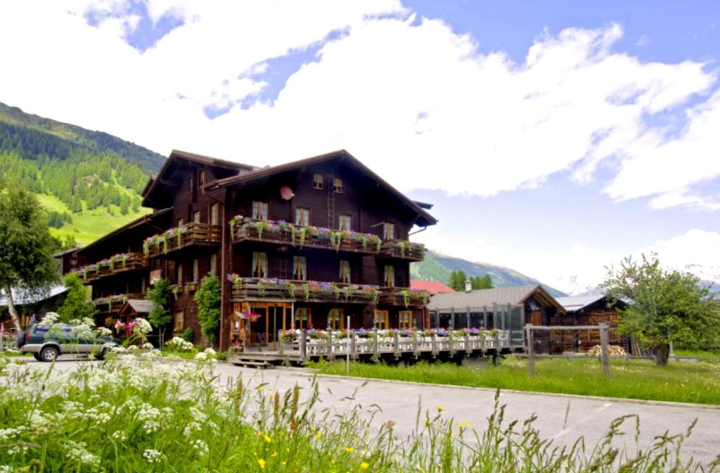 雷金根Swiss Lodge Joopi的一座大型的原木建筑,带有山景阳台