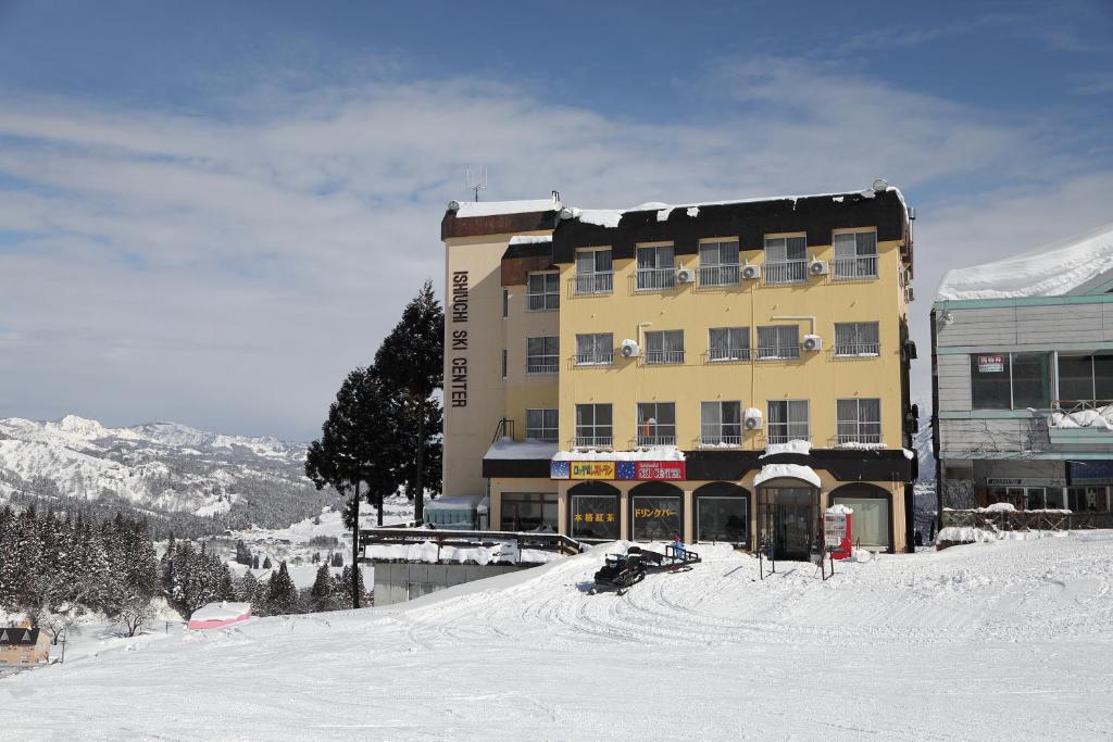 南鱼沼市Ishiuchi Ski Center的一座大建筑,位于一座白雪覆盖的山顶上