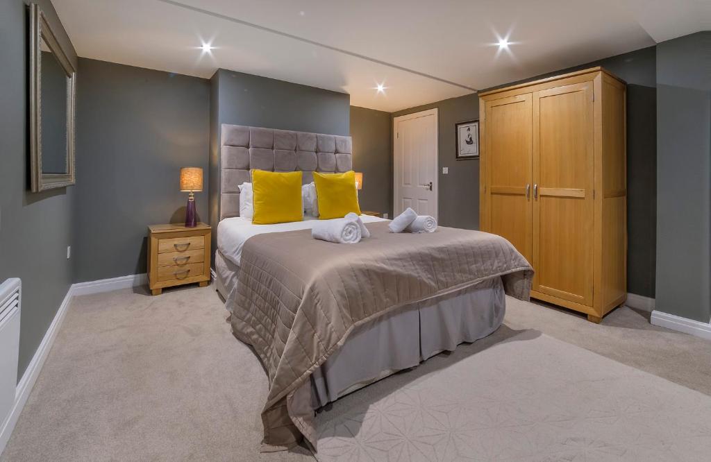 约克Gillygate Boutique Apartment- Stunning City Centre 1 Bedroom Apartment的一间卧室配有一张带黄色枕头的大床