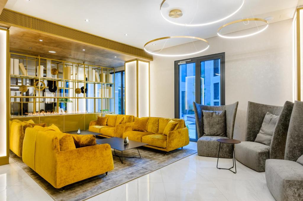 布达佩斯Emerald Hotel的客厅配有黄色的沙发和椅子