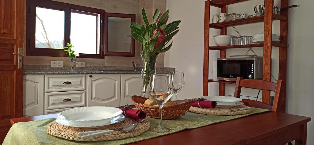 克鲁兹·德·特赫达Casa Ada的一张桌子上放有盘子和一杯葡萄酒