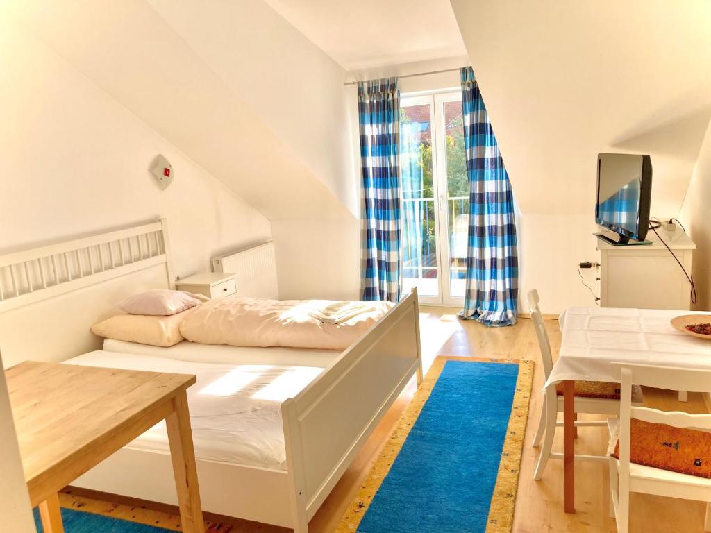 维也纳Gästezimmer Puzwidu的一间卧室配有一张床、一张桌子和一台电视。