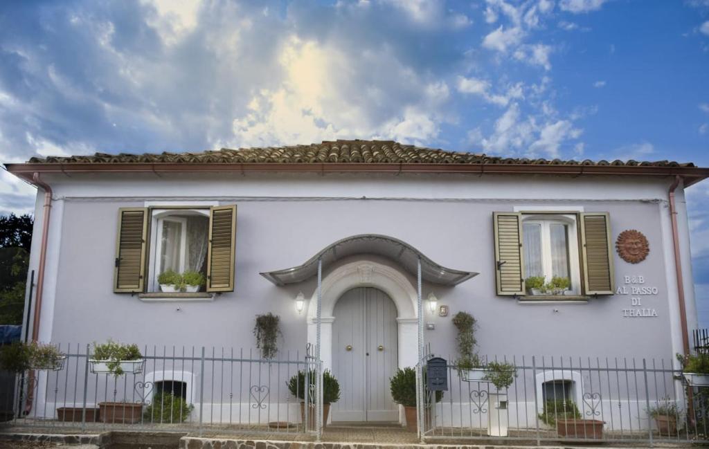 里卡迪Al Passo di Thalia的白色的房子,设有绿色百叶窗和门