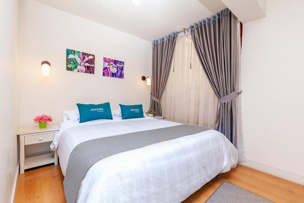 帕斯托Ayenda Casa La Castellana的一间卧室设有一张大床和一个窗户。