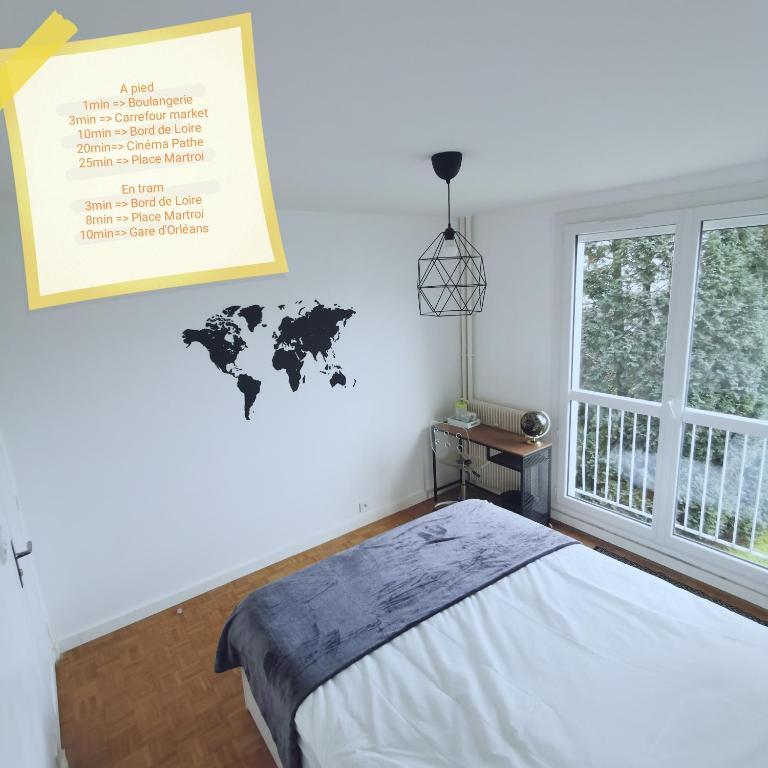 奥尔良Chambre Monde Tout confort Saint-Marceau的一间卧室配有一张床,墙上挂着一张世界地图
