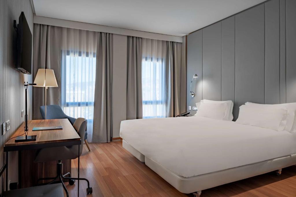 昆卡NH昆卡城市酒店的卧室配有一张白色大床和一张书桌