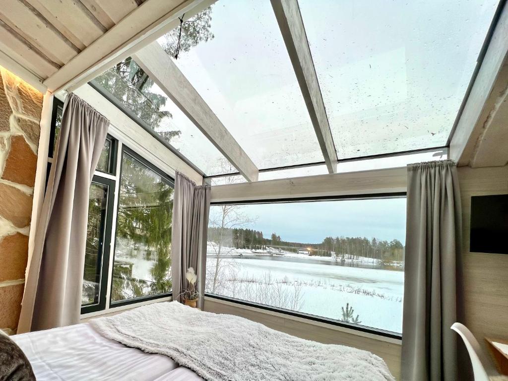 劳卡Glass Igloos by the water - Lasisviitit的一间带大窗户的卧室和一张位于客房内的床