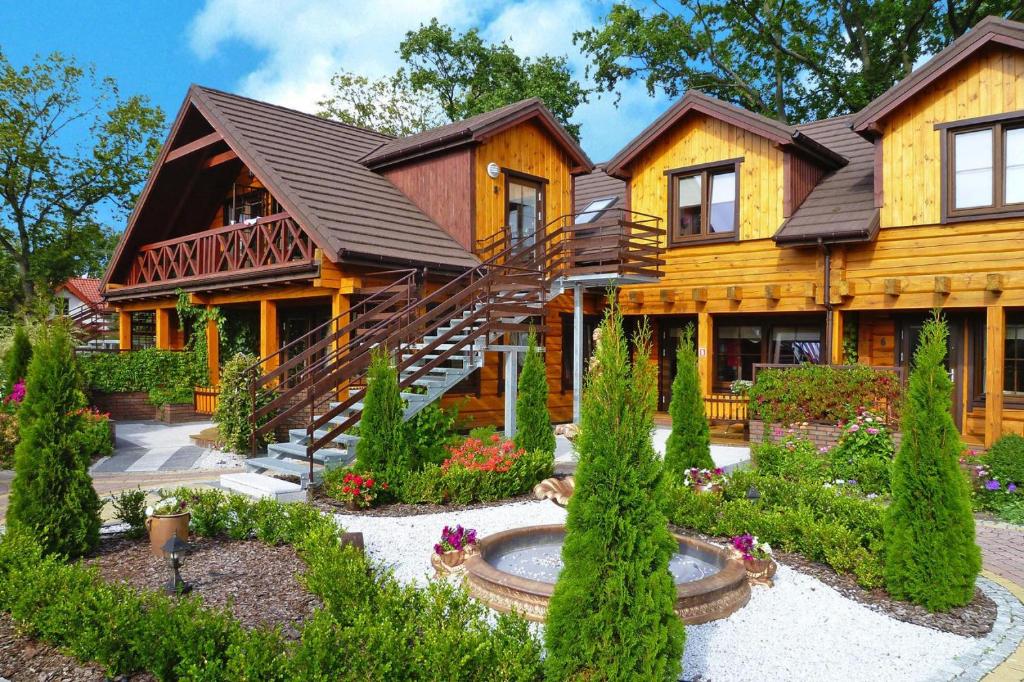 尤斯托尼莫斯基Holiday resort, Ustronie Morskie的小木屋前方设有花园