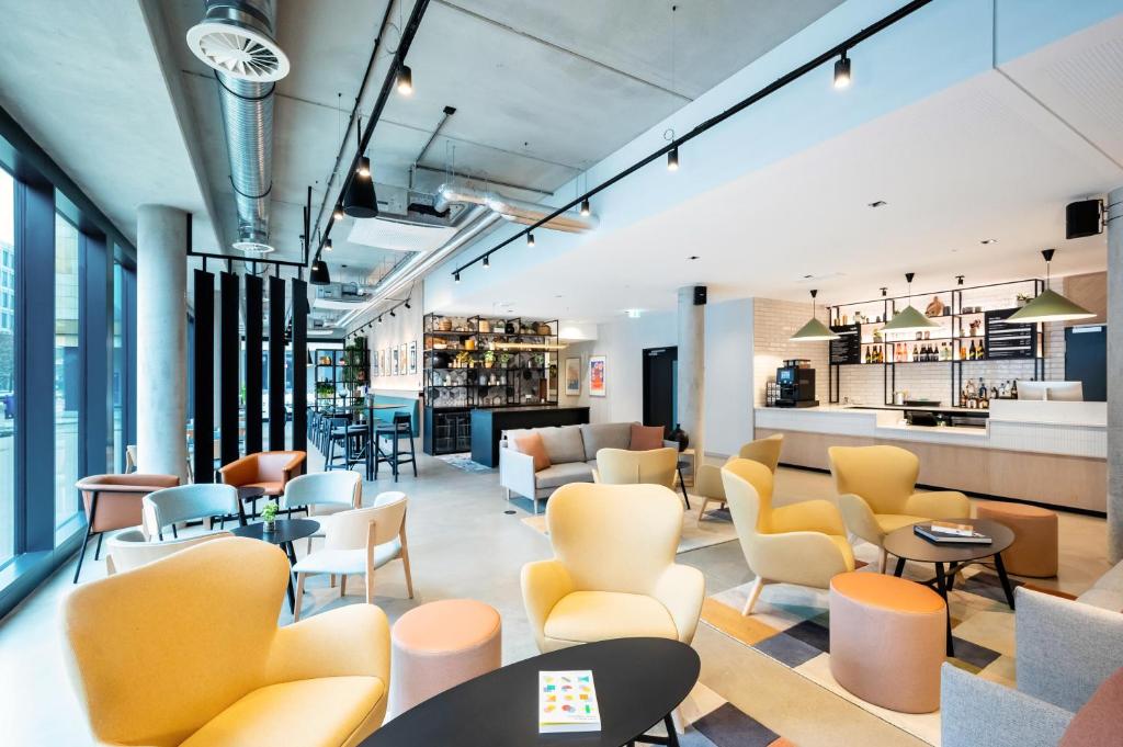 美因河畔法兰克福Staycity Aparthotels Frankfurt Airport的大堂设有桌椅和酒吧。